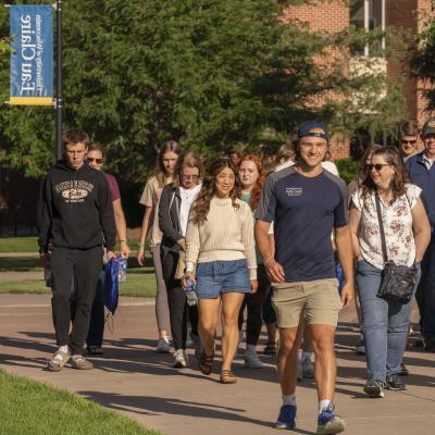 student leading a tour group outdoor on campus 