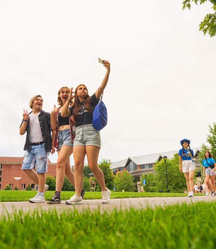 three visiting students taking a selfie on the mall sidewalk 